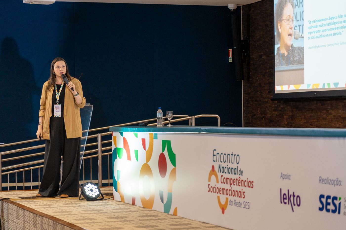 Juliana palestrando no palco do Encontro Nacional de Competências Socioemocionais da Rede SESI